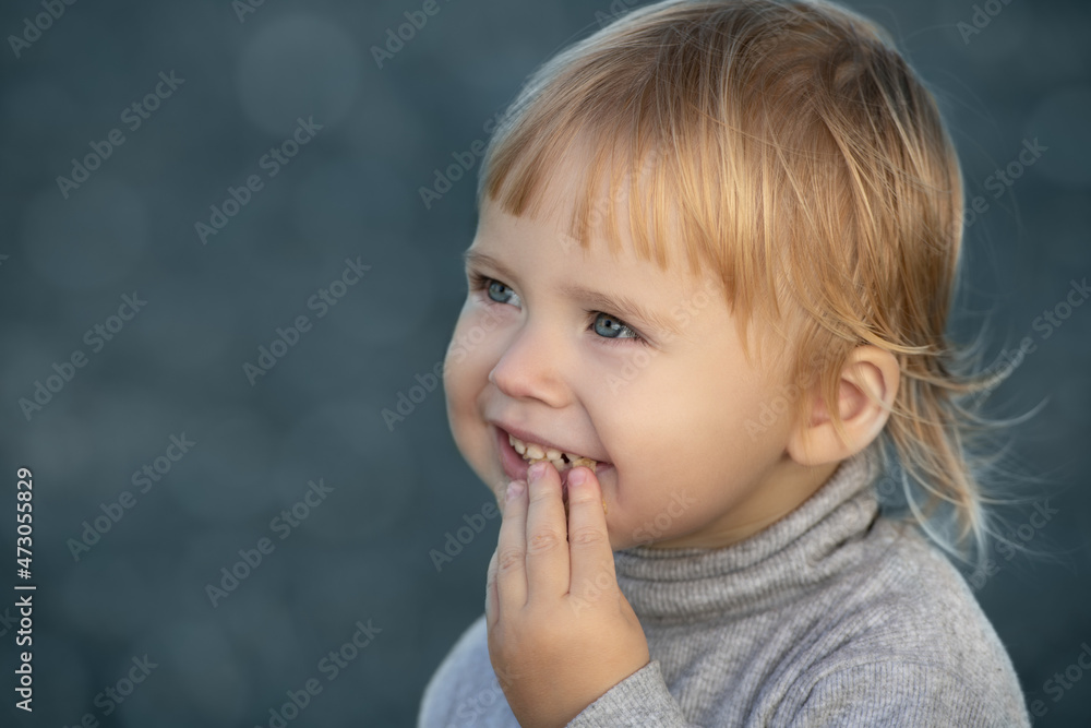 Child smiles face portrait on blue bokeh background Child smiles face portrait on blue bokeh background