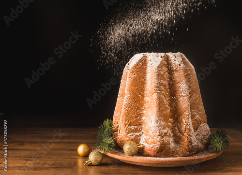 Pandoro traditional italian Christmas sweet cake bread with icing sugar copy space black background.