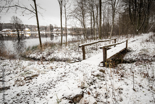 A snow-covered wooden bridge by the lake, Vecumnieki, Latvia photo