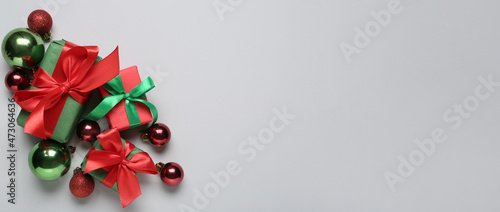 Christmas gifts and beautiful balls on light background with space for text