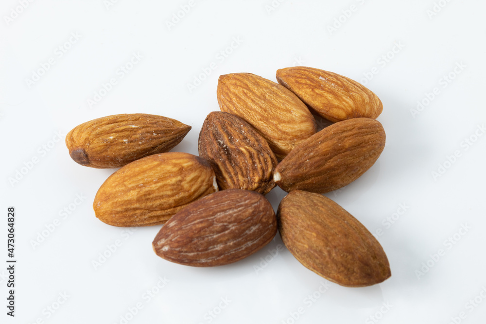 Serving of whole roasted almonds, ready to eat, isolated on white background Serving of whole roasted almonds, ready to eat, isolated on white background
