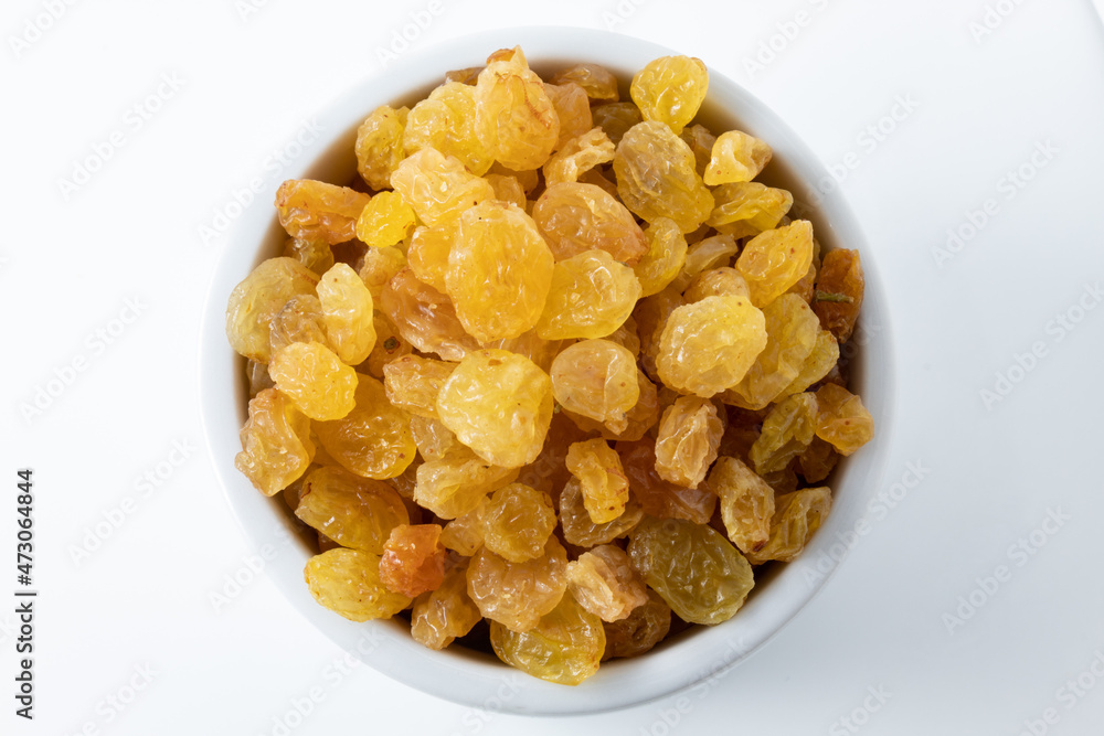 Top view of dried white raisins or sultanas in a white ceramic pot, isolated on white background Top view of dried white raisins or sultanas in a white ceramic pot, isolated on white background