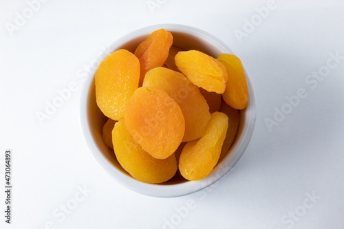 Top view of dried and seedless Turkish apricots in ceramic ramekin