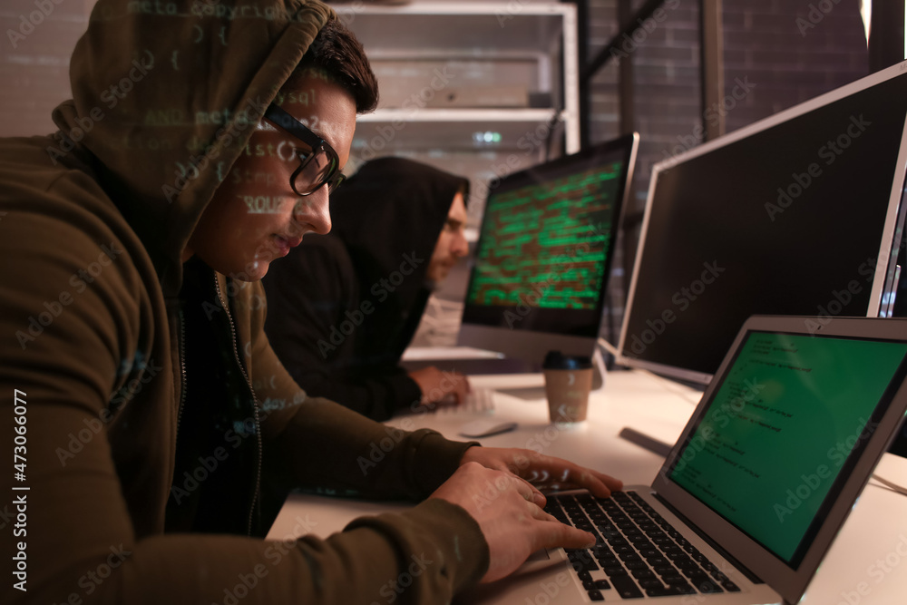 Hackers using computers in dark room Hackers using computers in dark room