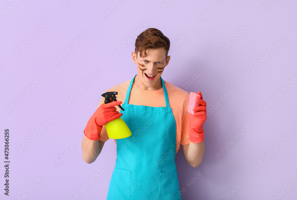 Handsome man with cleaning sponge and detergent on lilac background