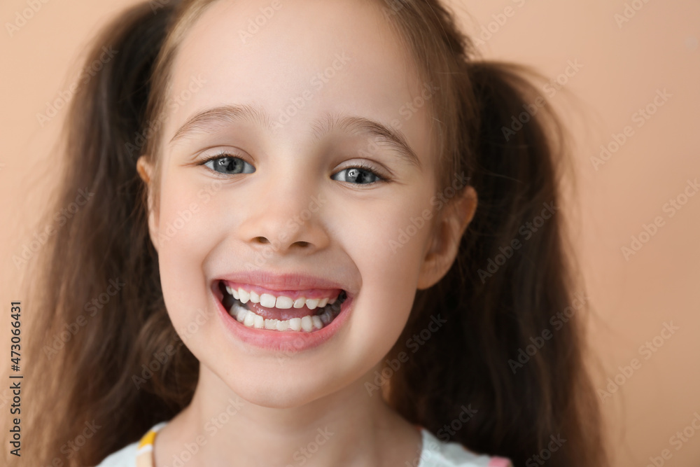 Portrait of smiling little girl with ponytails on beige background, closeup Portrait of smiling little girl with ponytails on beige background, closeup
