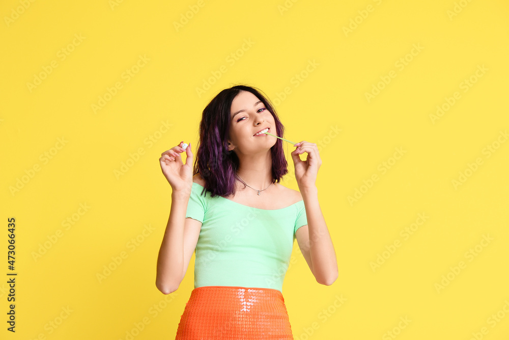 Young woman with chewing gums on yellow background Young woman with chewing gums on yellow background