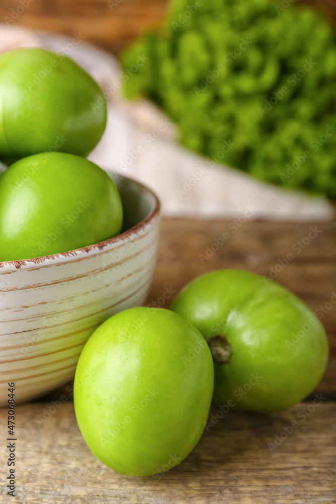 Bowl of fresh green tomatoes on wooden background, closeup Bowl of fresh green tomatoes on wooden background, closeup