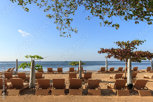 An unmanned beach full of beach chairs and parasols in the morning photo