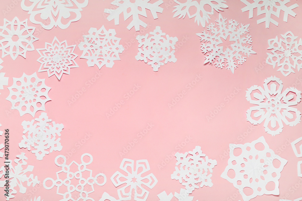 Frame made of beautiful paper snowflakes on pink background Frame made of beautiful paper snowflakes on pink background