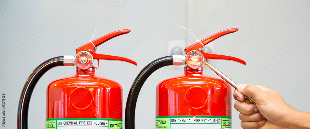 Fire extinguisher, Hand of engineer inspection checking pressure gauge level fire extinguisher tank of protection and prevent emergency and safety rescue and fire alarm system training.
