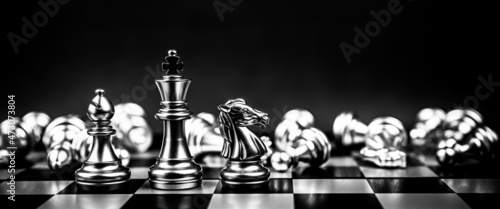 Fotografia Close-up king chess bishop and knight standing teamwork with falling chess pieces concepts of business team and leadership strategy and organization risk management or team player