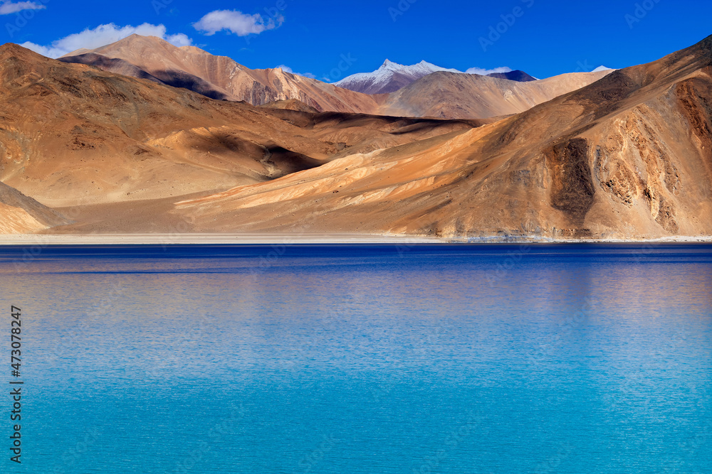 Blue water of Pangong tso (Lake). It is huge lake in Ladakh, shared by China and India along India China LOC border, Himalayan mountains alonside from India to Tibet. Leh, Ladakh, India.