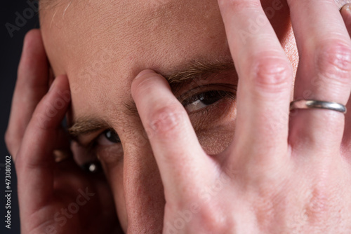 Closeup man with serious closeup face. Guy covered face with hands and doing stop gesture with sad and fear expression.