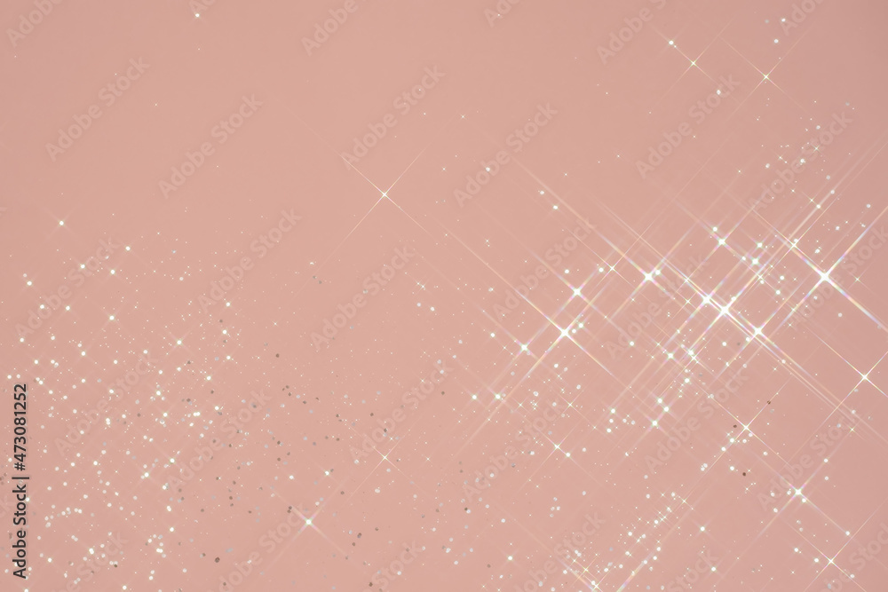 Abstract pink background with sparkles in the shape of stars.