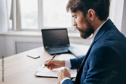 Man sitting at a desk in front of a laptop finance network technologies