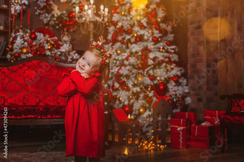 charismatic little girl in a red dress on the background of Christmas decorations   © Татьяна Добрикова