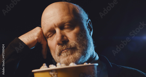 Foto Man watching a boring movie at the cinema