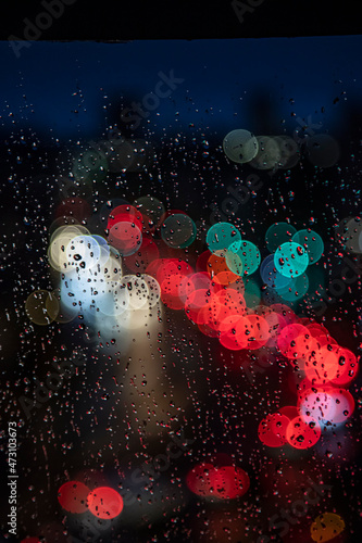 rainy days.rain drops on the window and traffic bokeh in distance © babaroga