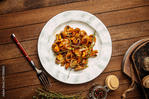 Fototapeta Naklejka Na Ścianę i Meble -  Portion of gourmet fried mushrooms with onion garnish