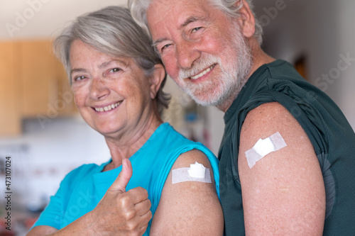 Beautiful senior couple 70 years old smiling after receiving the booster of the coronavirus covid-19 vaccine. Concept of prevention and immunization photo