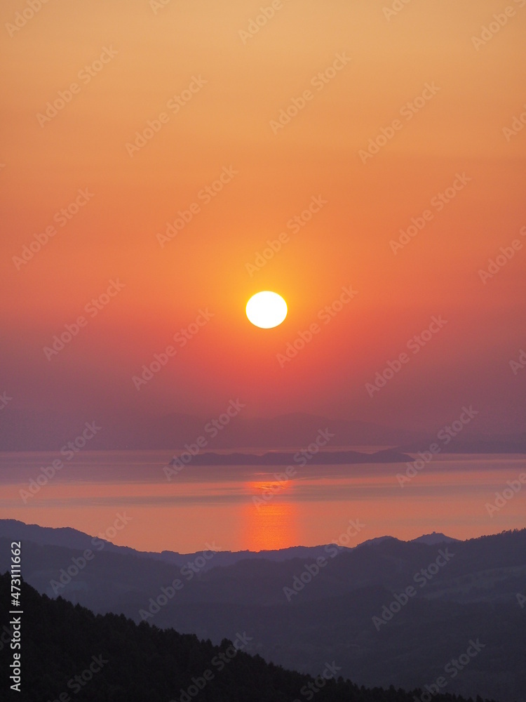 高原から、海と夕日を見る
