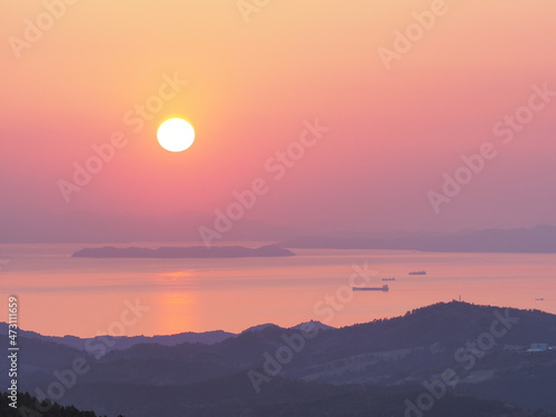 高原から、海と夕日を見る