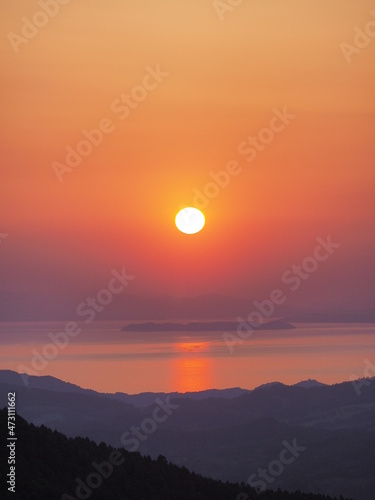 高原から、海と夕日を見る