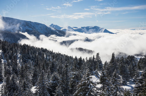 paysage alpin: Chamrousse et le massif de Belledonne sous la neige en hiver avec des nuages dans la vallée