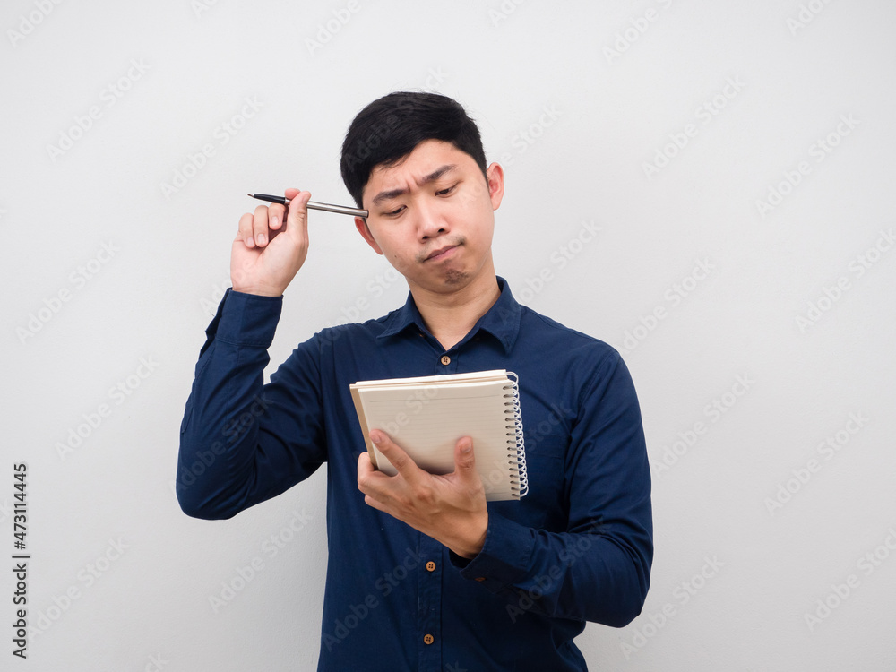 Man holding pen and looking at blank notebook in hand thinking something Man holding pen and looking at blank notebook in hand thinking something