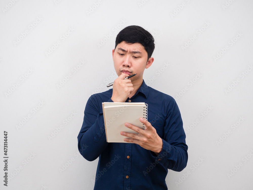 Man serious looking at paper notebook in hand thinking about work Man serious looking at paper notebook in hand thinking about work