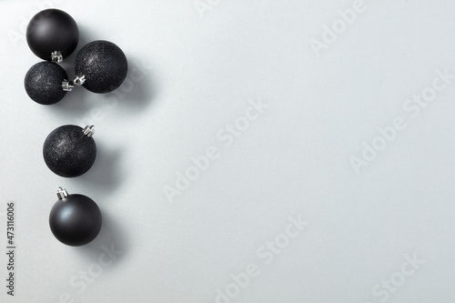 Black Christmas toys or decor on a gray background with copy space