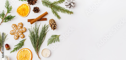 Christmas Banner. winter, new year composition. Christmas frame made of Fir tree branches, cinnamon sticks, candies, gingerbread on white background. Flat lay, top view, copy space