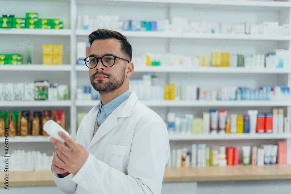 Portrait of a handsome pharmacist working in a pharmacy Portrait of a handsome pharmacist working in a pharmacy