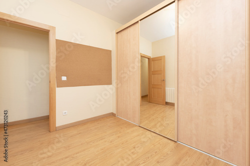Unfurnished room with large built-in wardrobe and oak parquet floors