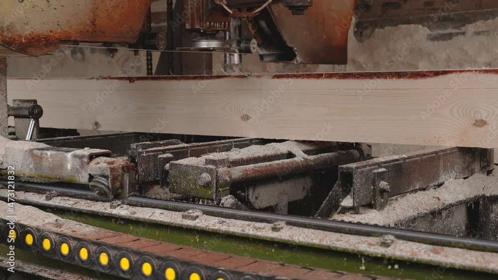 Sawing logs at a sawmill. The process of processing wood on a sawmill. Woodworking industry. Sawing logs at a sawmill. The process of processing wood on a sawmill. Woodworking industry.