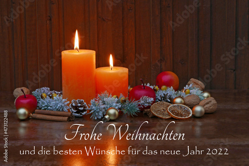 Weihnachtskarte: Arrangement mit Kerzen,Zweigen und dem Text frohe Weihnachten und die besten Wünsche für das neue Jahr 2022.