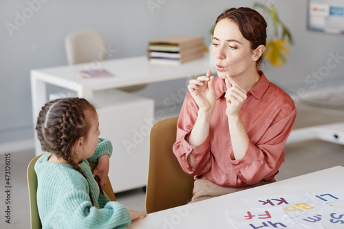 Foto Young English teacher teaching to pronunciate the English words the little girl