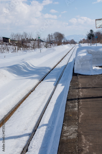 冬の田舎の無人駅と線路 