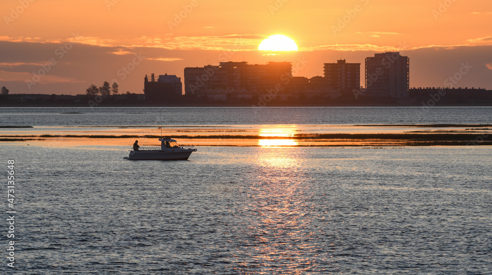 Sunrise in the Santoña marshes with Laredo in the background and a boat in the marsh