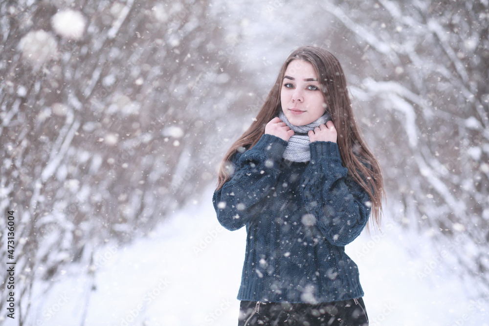 Girl in a winter park in snowfall Girl in a winter park in snowfall