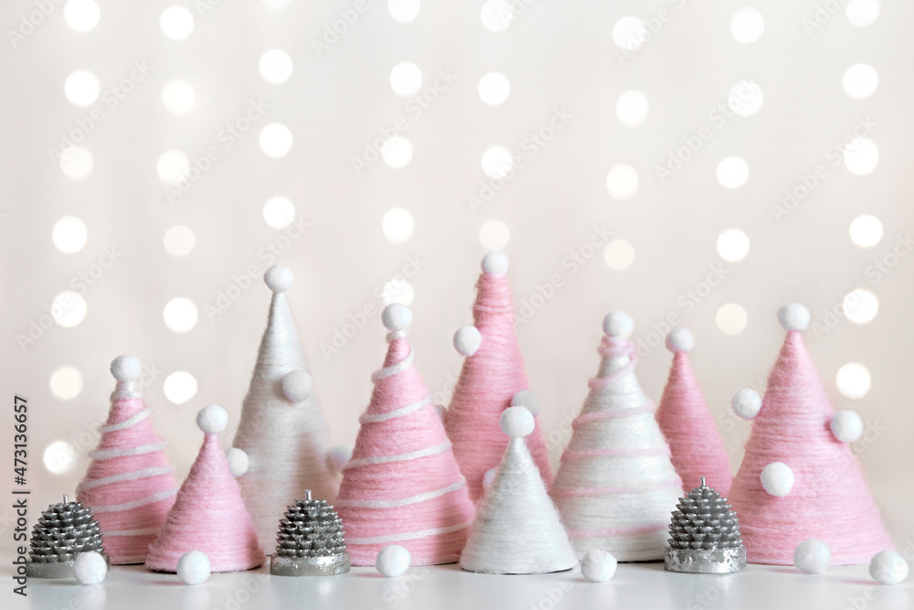 Diy Christmas trees is made of pink yarn. Eco-friendly fluffy Christmas decor on shining background