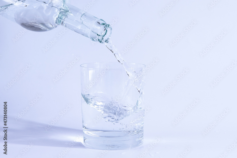 Pour water from the bottle into a glass. Isolated on white background. Pour water from the bottle into a glass. Isolated on white background.