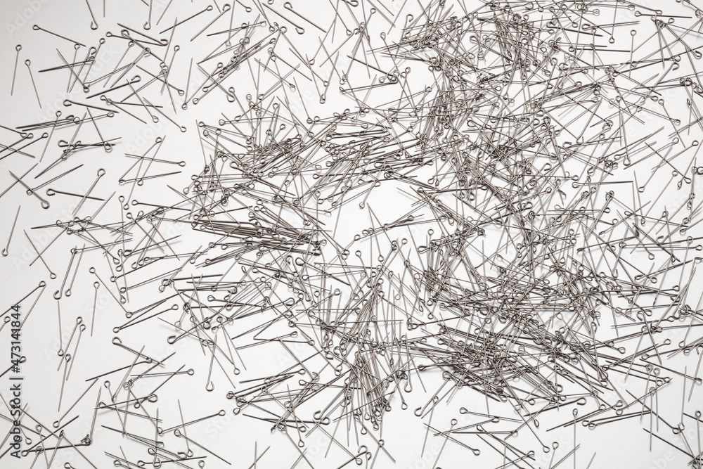 A lot of sewing pins on white background. 
