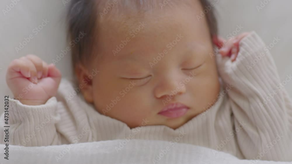 Close up happy newborn baby lying sleeps on a white blanket comfortable and safety.Cute Asian newborn sleeping and napping on bed.Newborn Baby photography concept Close up happy newborn baby lying sleeps on a white blanket comfortable and safety.Cute Asian newborn sleeping and napping on bed.Newborn Baby photography concept