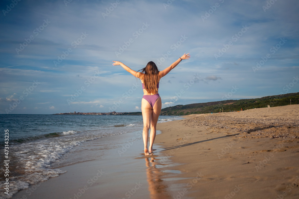 Happy beautiful woman walking on the beach on sunlight. Happy beautiful woman walking on the beach on sunlight.