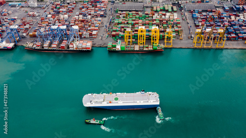Aerial top view tugboat dragging Large RoRo (Roll on/off) into Commercial dock import and export international on the green sea