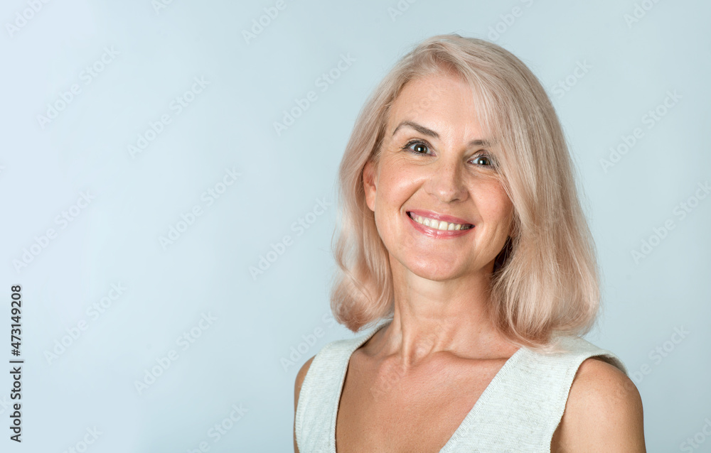Attractive elderly woman with gray hair in casual clothes posing on a light background in the studio. Makeup and senior elderly skincare Attractive elderly woman with gray hair in casual clothes posing on a light background in the studio. Makeup and senior elderly skincare