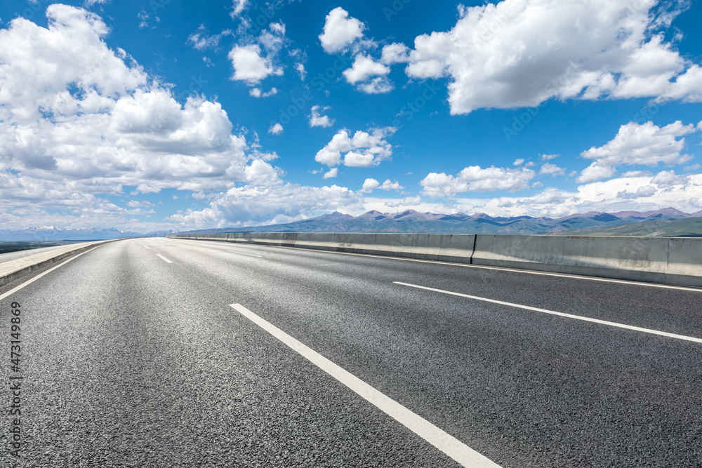 Asphalt road and mountain under blue sky. Highway and mountain background. Asphalt road and mountain under blue sky. Highway and mountain background.