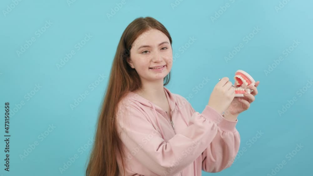 Dental Beautiful smiling of young woman with retainer braces glad emotion with white teeth increase confidence for healthy on blue background isolated, Happy funny teen girl brush . Dental Beautiful smiling of young woman with retainer braces glad emotion with white teeth increase confidence for healthy on blue background isolated, Happy funny teen girl brush .